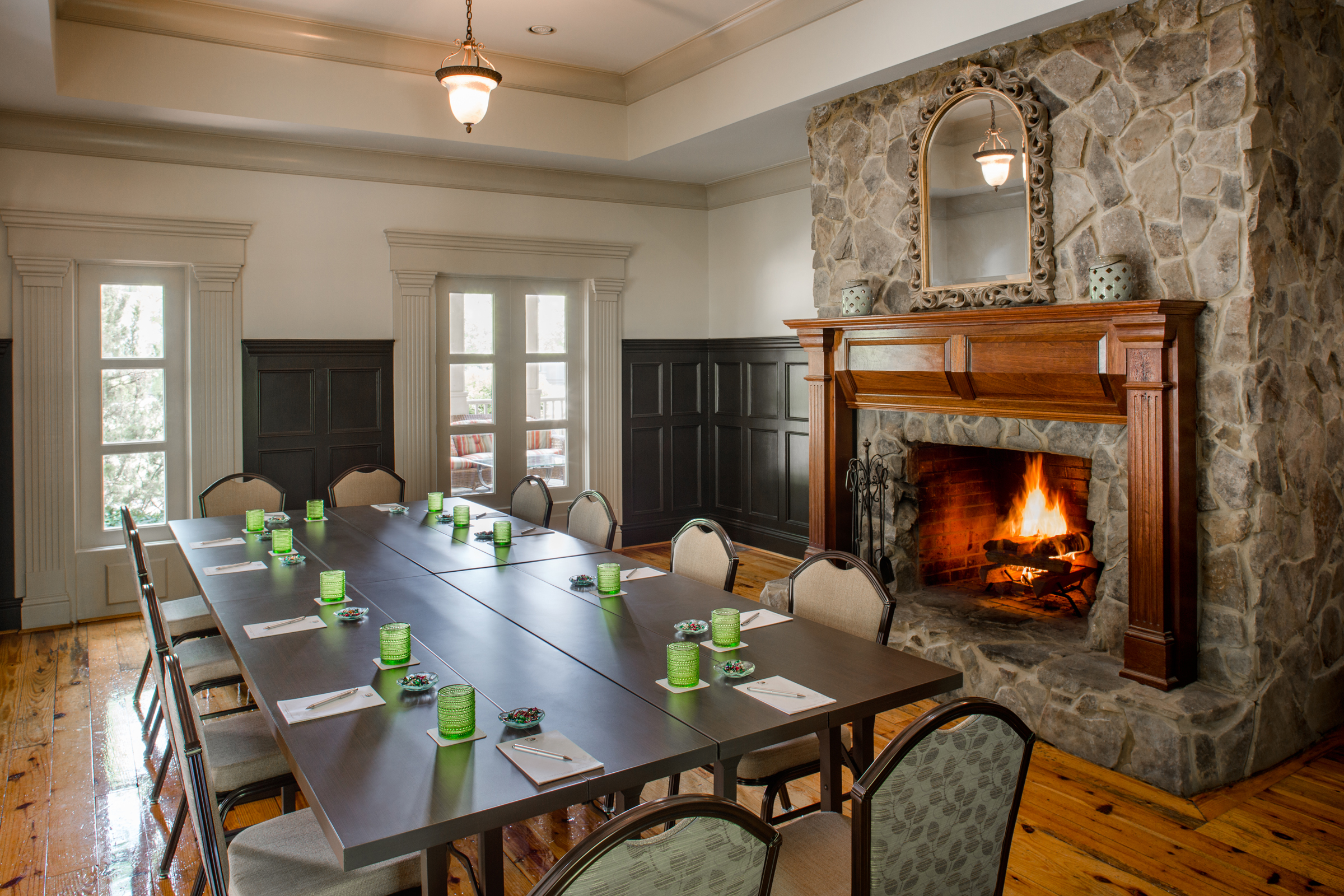 The Osage Room at Birch Cottage, a meeting table is set up in front of a large fireplace.
