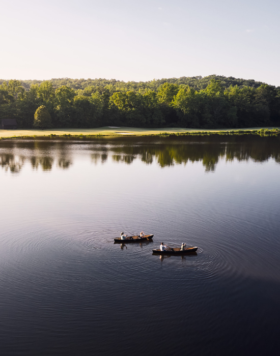 aerial image of people in two canoes on a lake.
