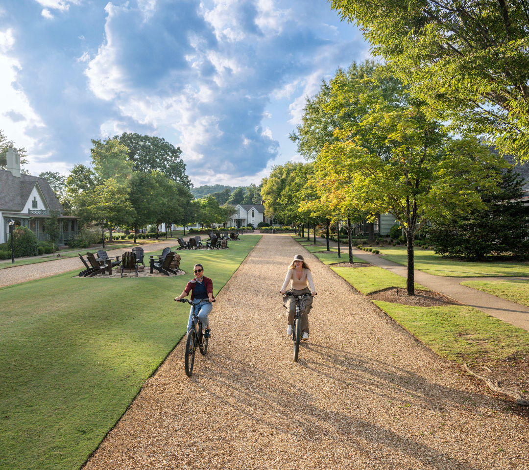 Two ladies biking on a resort pathway