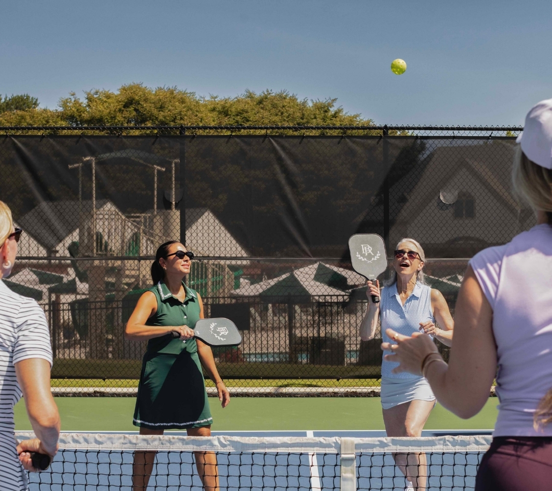 a group of women playing pickleball
