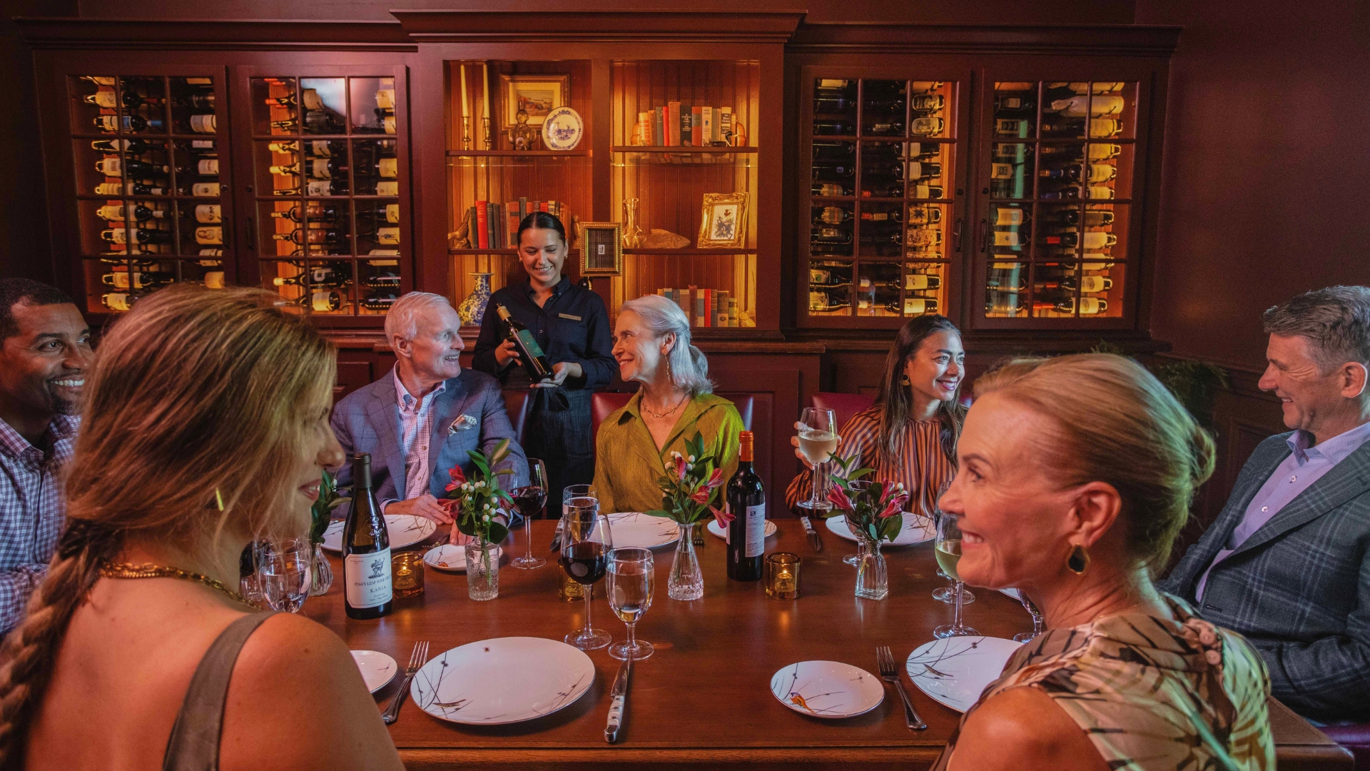 a groups of adults dining in a small room