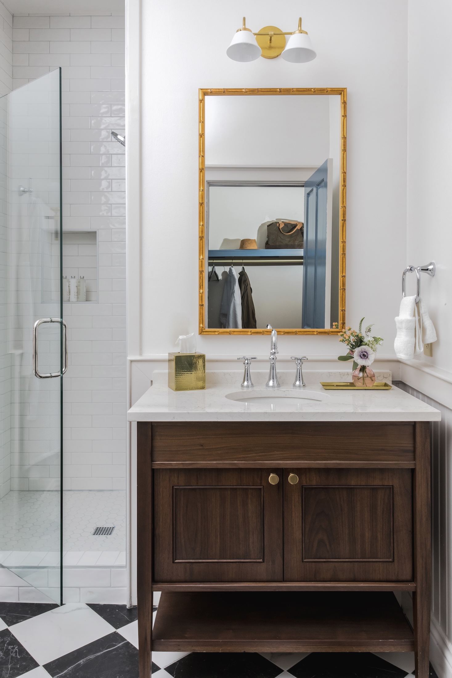 The sink and shower area of the washroom in a cottage at Barnsley Resort. The closet can be seen in the mirror above the sink.