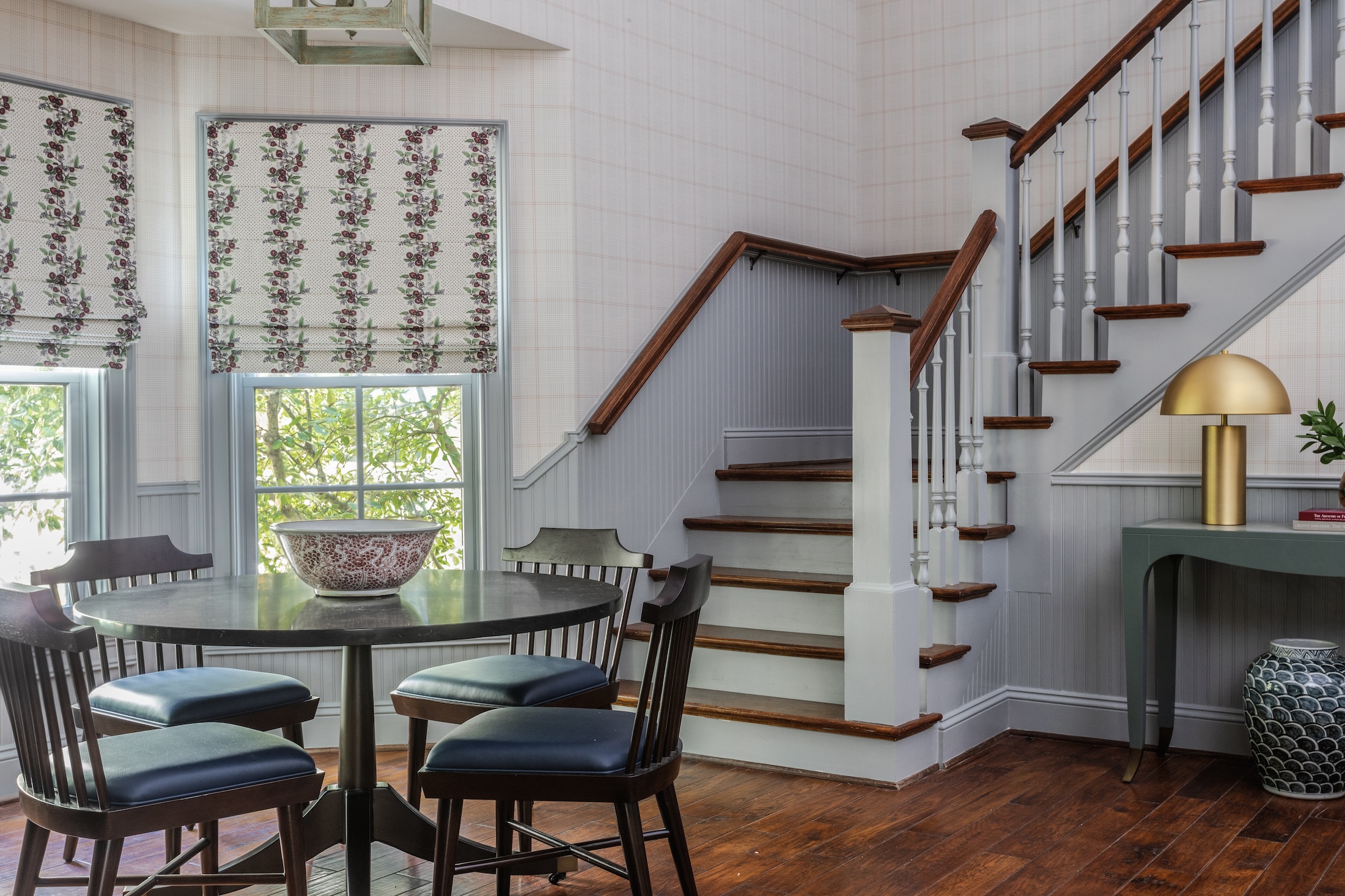 The dining area in a bay window of the Julia Cottage at Barnsley Resort with stairs leading to the upper part of the cottage.