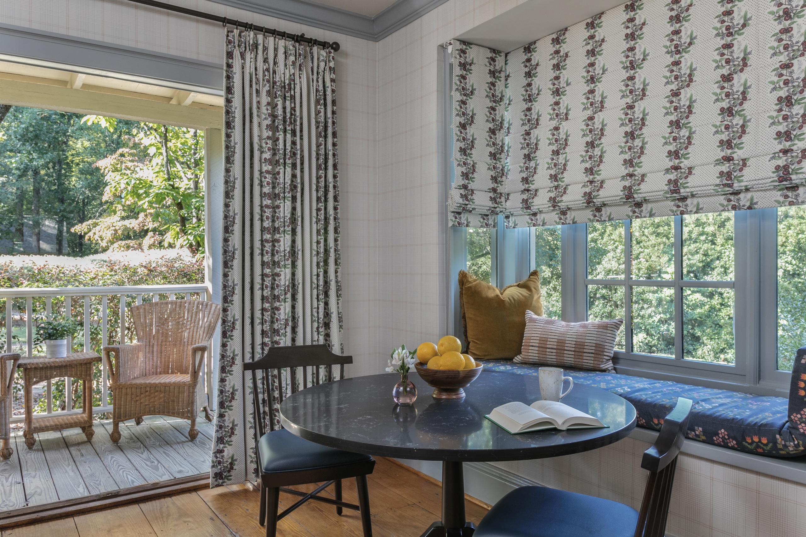 A small seating area in Wheaton Cottage in front of the furnished patio on a sunny day.