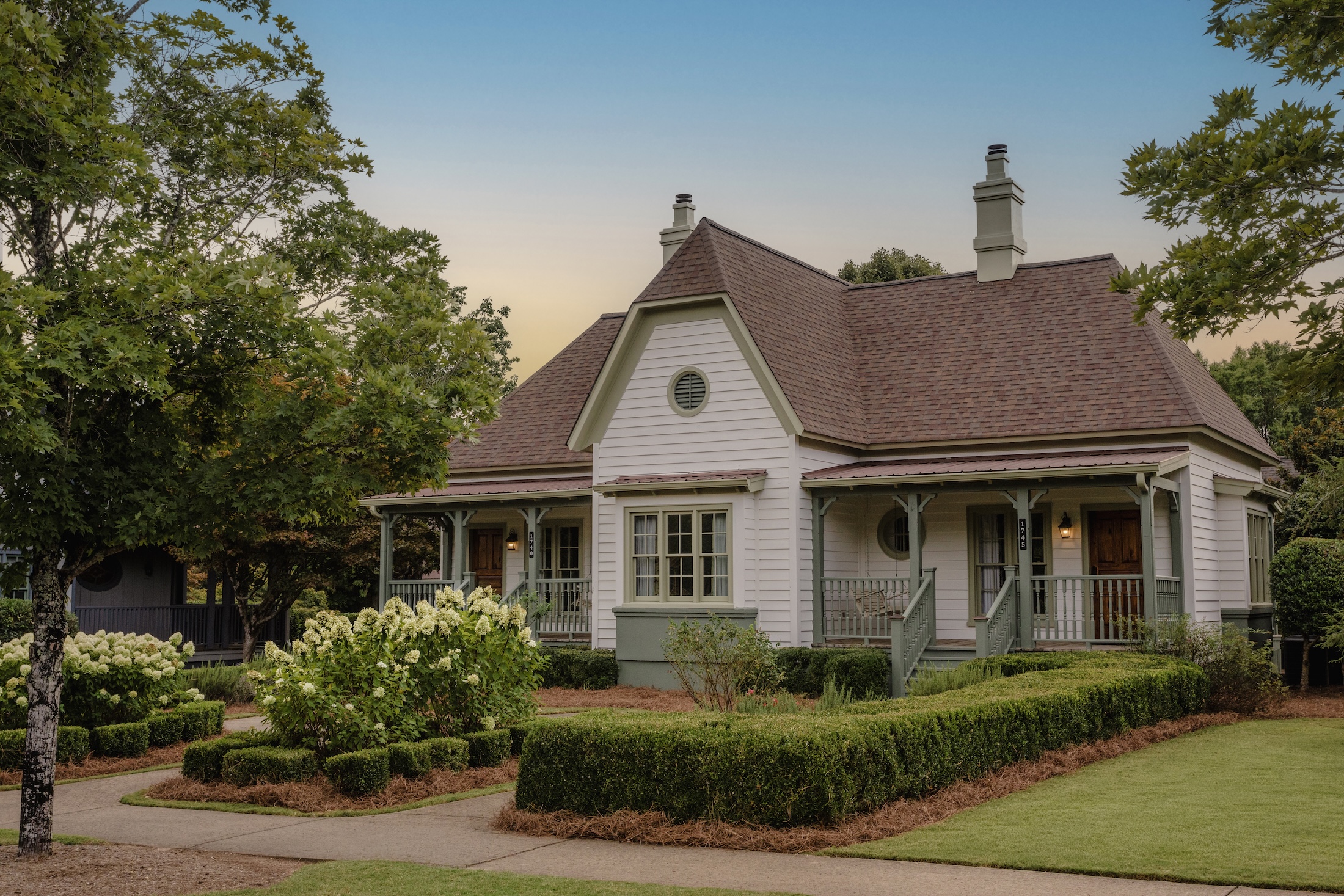 The exterior of a one bedroom cottage suite at Barnsley Resort. The walk way leading up is lined with hedges.