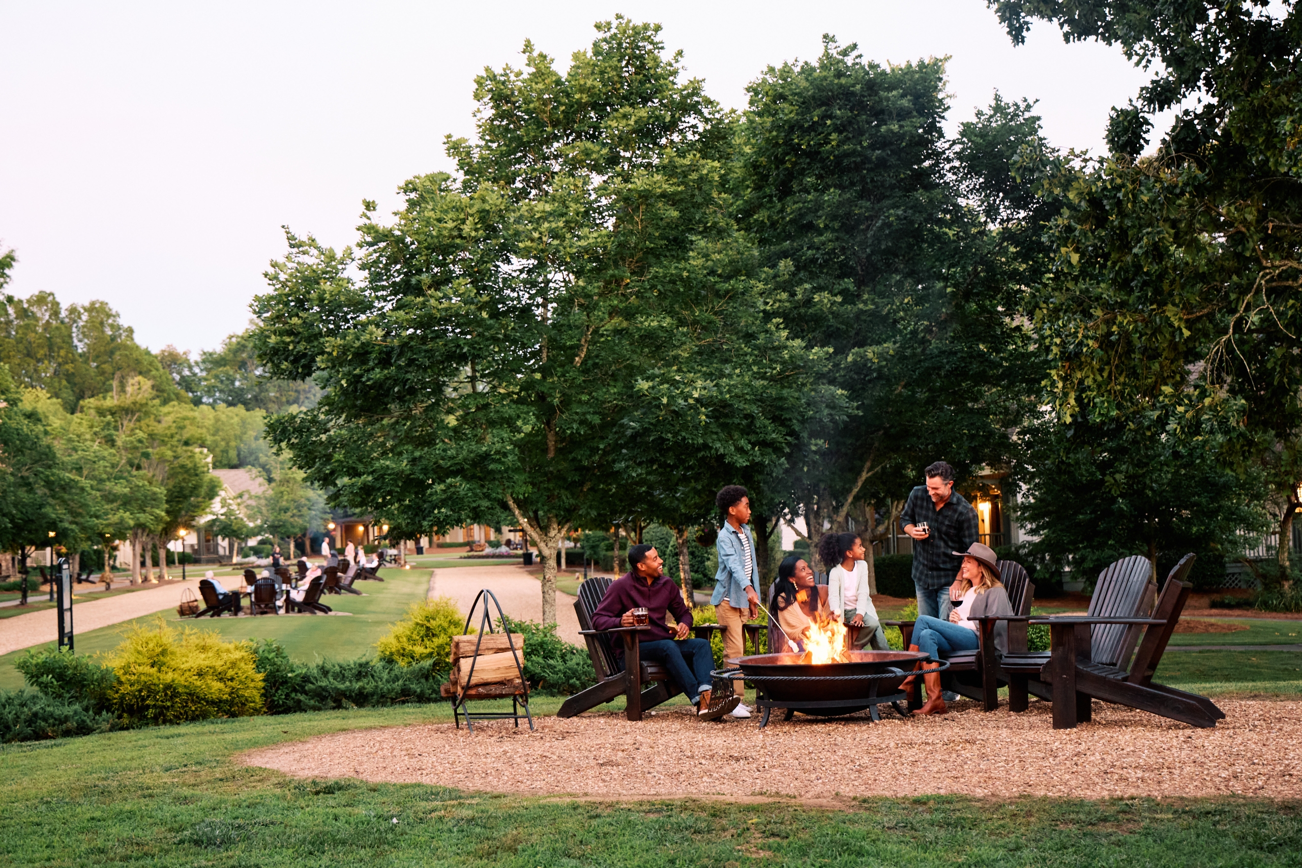 A group of people gather around a firepit.