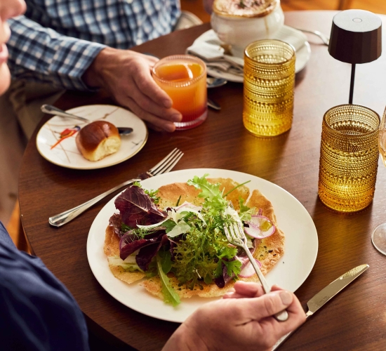 A tabletop with a plate of music paper bread and glasses.