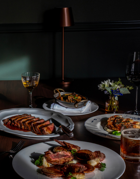 A restaurant table with dishes of entrees and beverages