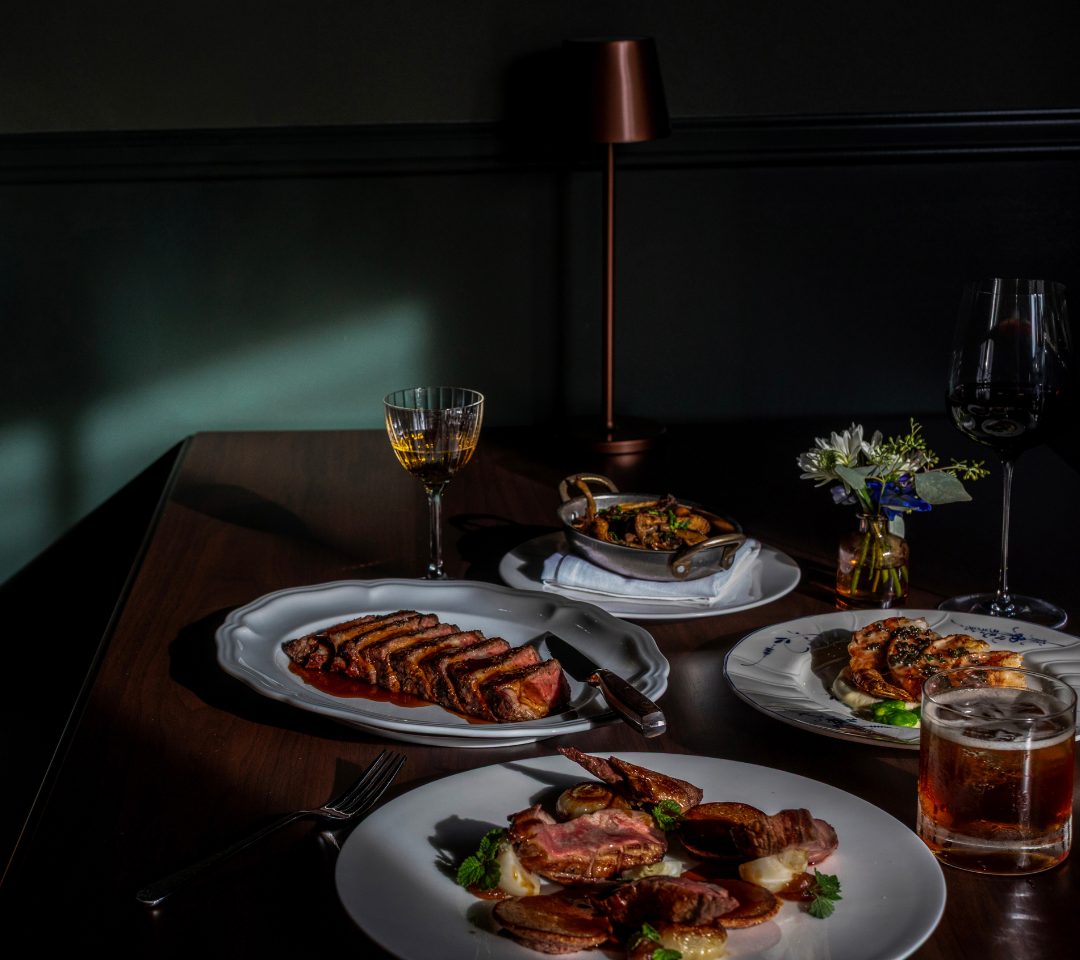 A restaurant table with dishes of entrees and beverages