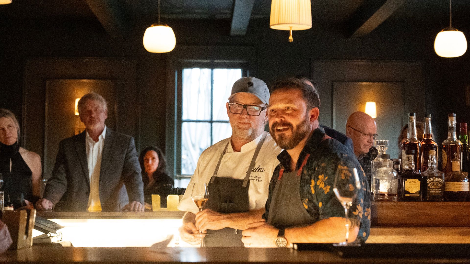 two chefs talking to group of people