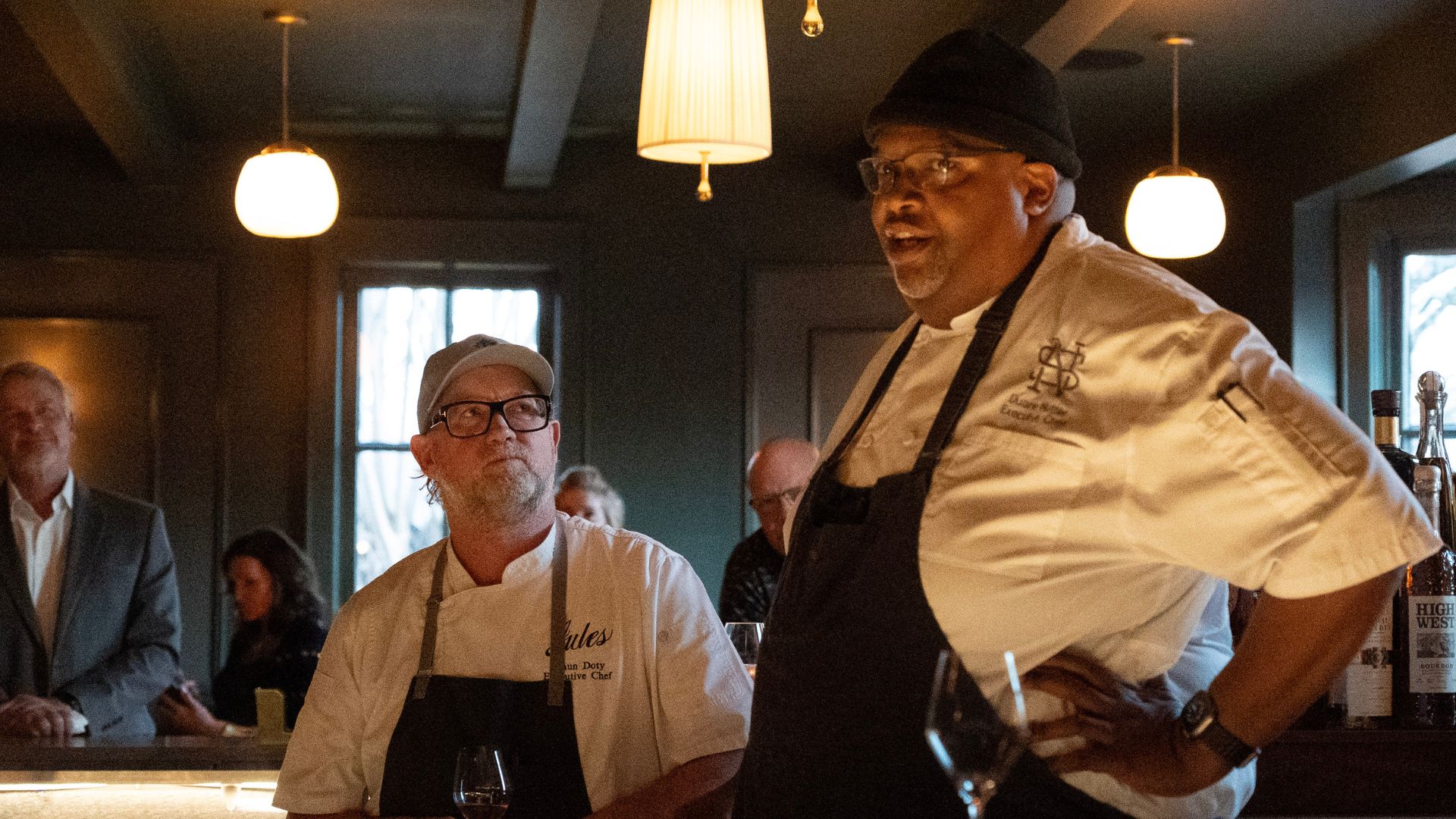 two chefs talking to group of people