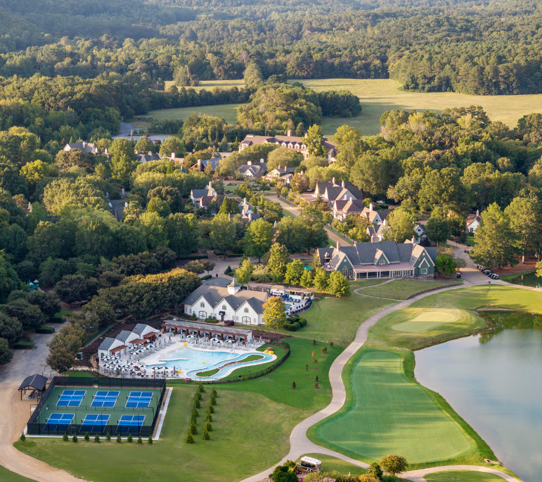 aerial of resort pools, pickleball courts, buildings, and golf course.