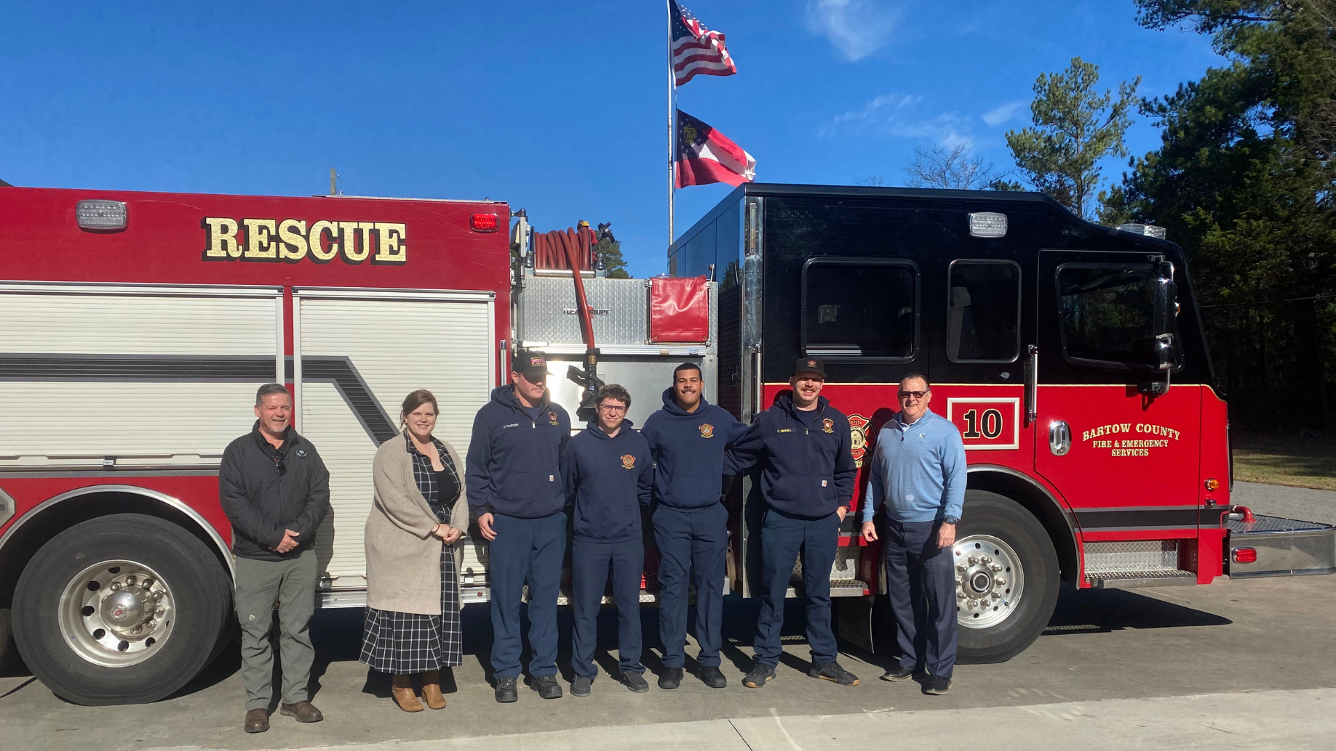 men and woman standing in front of a firetruck