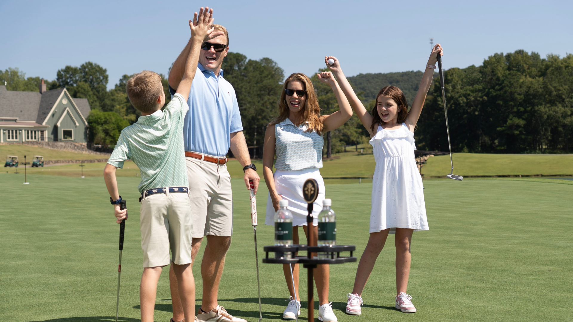 family high-fiving on a putting course