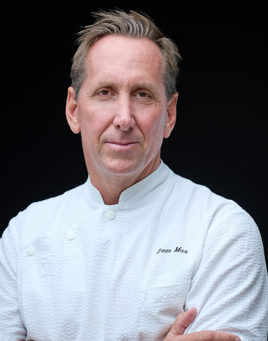 man in chef's coat smiling at camera