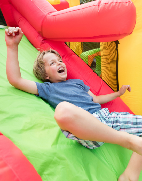 little boy sliding down an inflatable slide