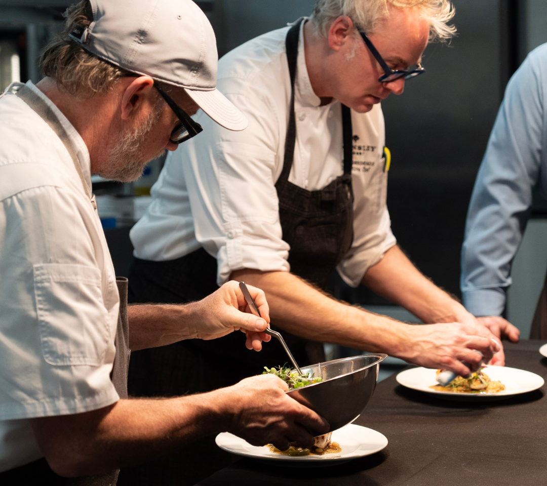 chefs plating food in a kitchen