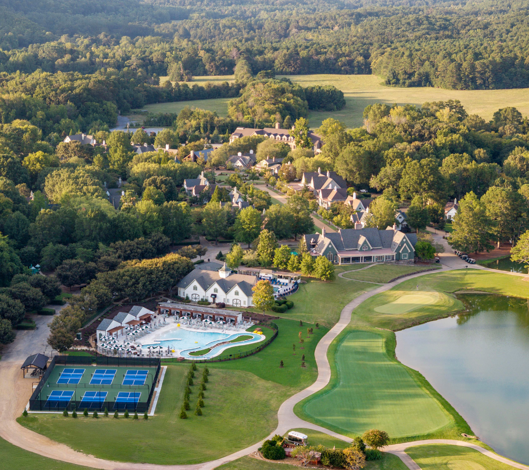 aerial of resort pools, pickleball courts, buildings, and golf course.