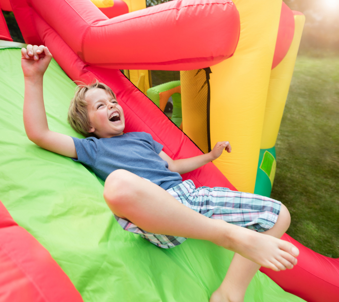 little boy sliding down an inflatable slide
