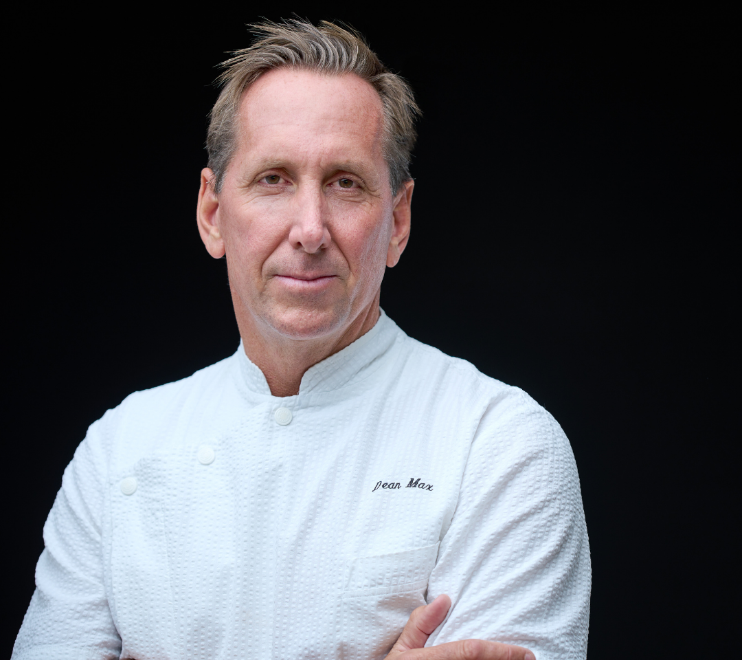 man in chef's coat smiling at camera