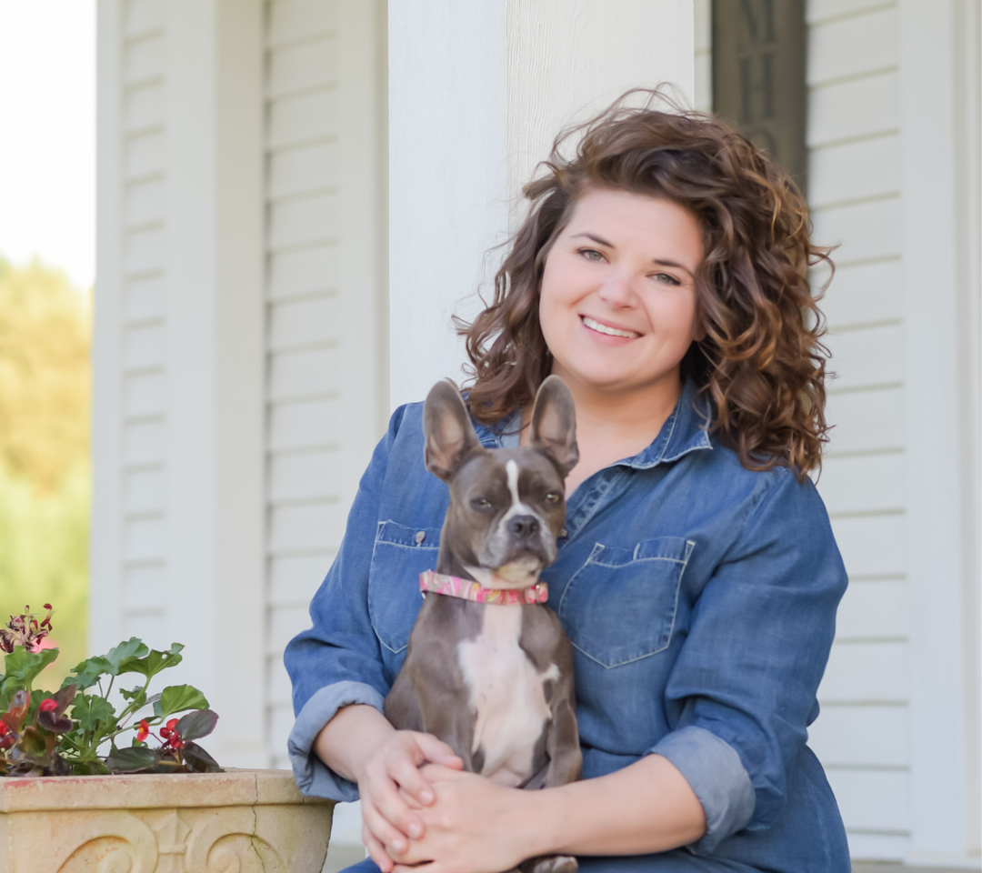 woman with dog in her lap smiling at camera