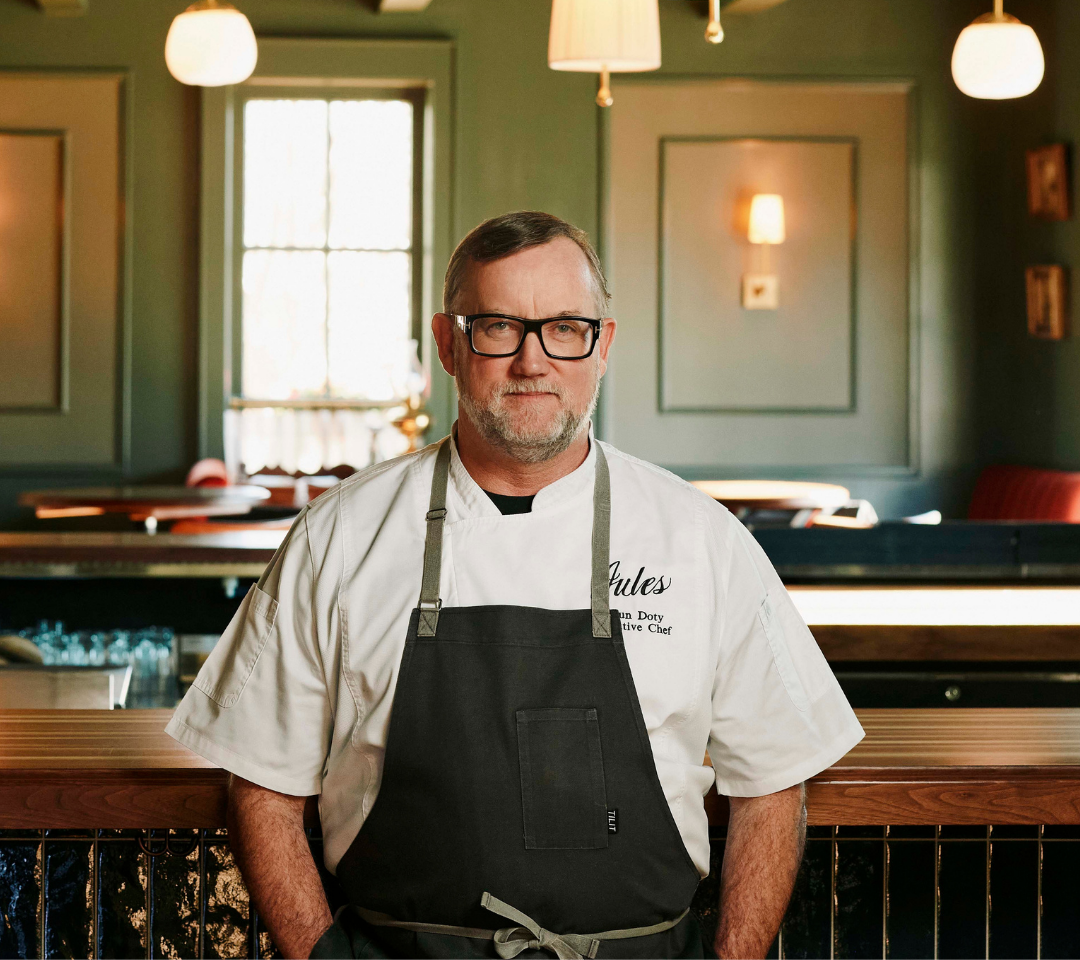man in chef's coat smiling at camera