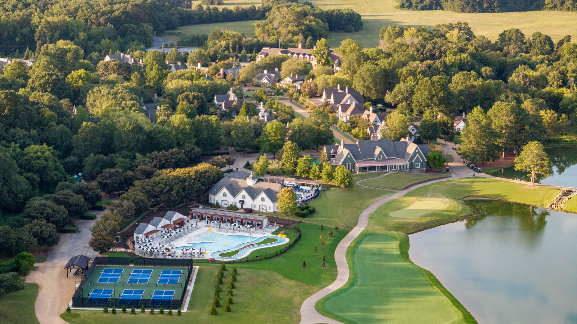 aerial of resort pools, pickleball courts, buildings, and golf course.