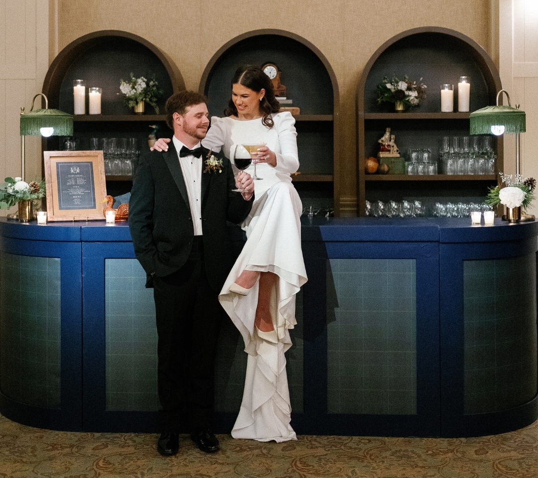 man and woman at a bar clinking their beverages