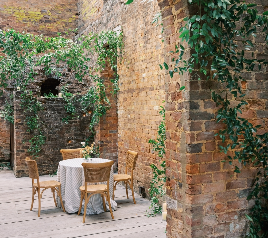 brick building with table and chairs set up for wedding