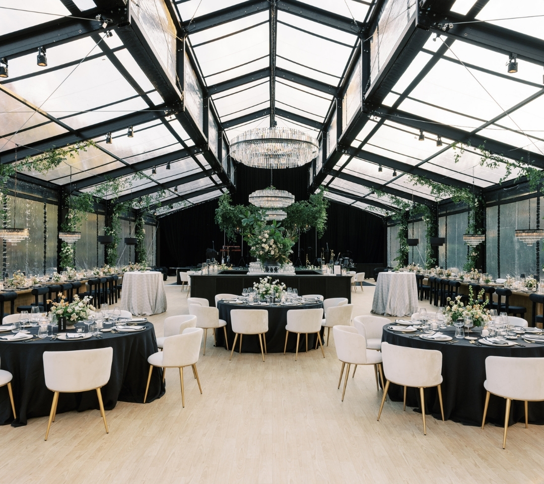 black glass tent with wedding seating and decor