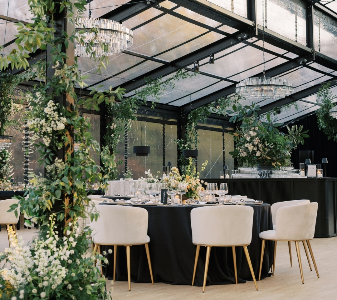 black glass tent with wedding seating and decor