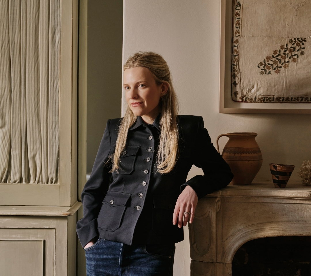 woman standing near fireplace with arm propped on mantel