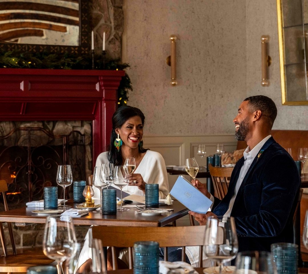 couple sitting at restaurant table, smiling at each other