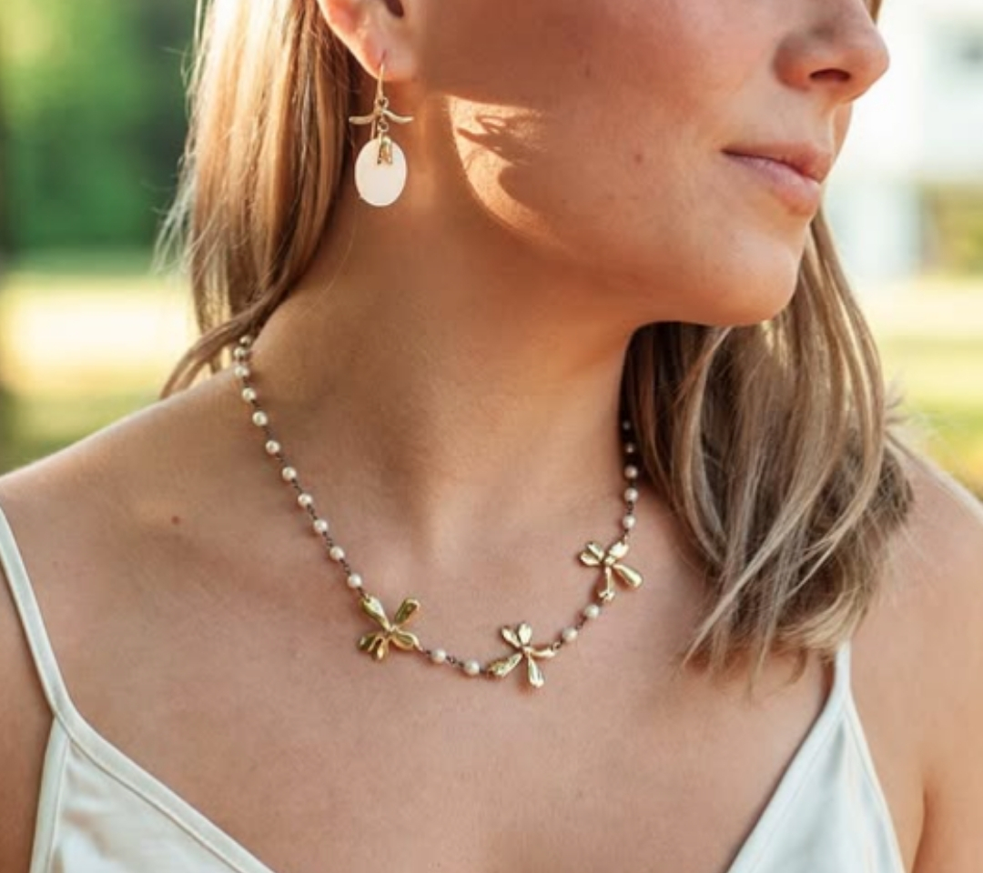 close up of a necklace and earring on a woman
