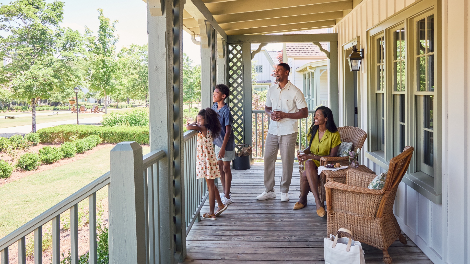 family of four sitting and standing on a porch
