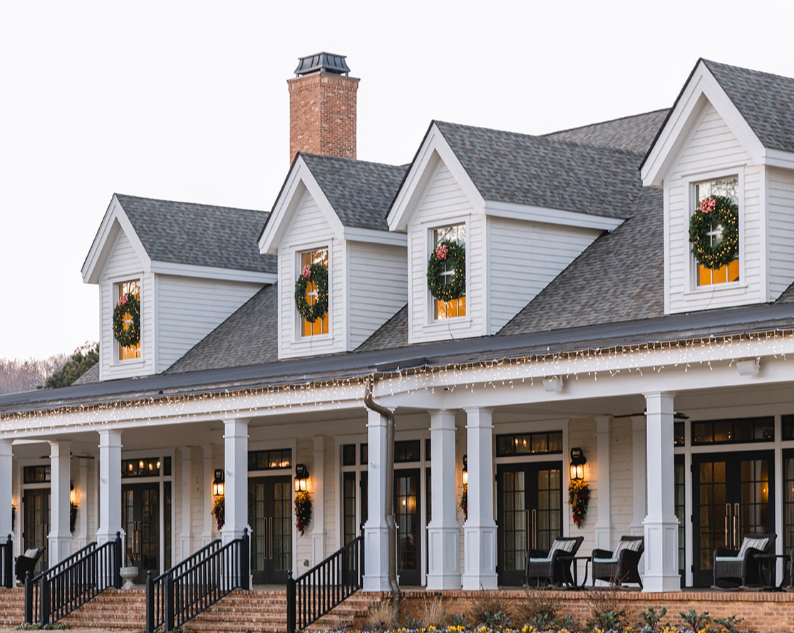a large white building with wreaths hanging on doors and windows
