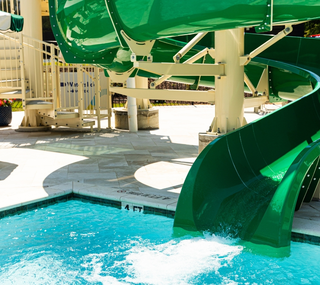 a green waterslide at a pool