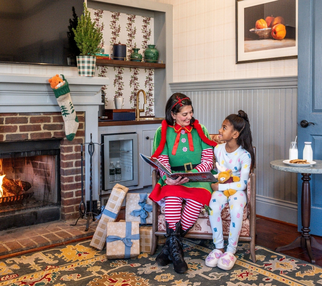 a woman and child sitting in a chair reading a book